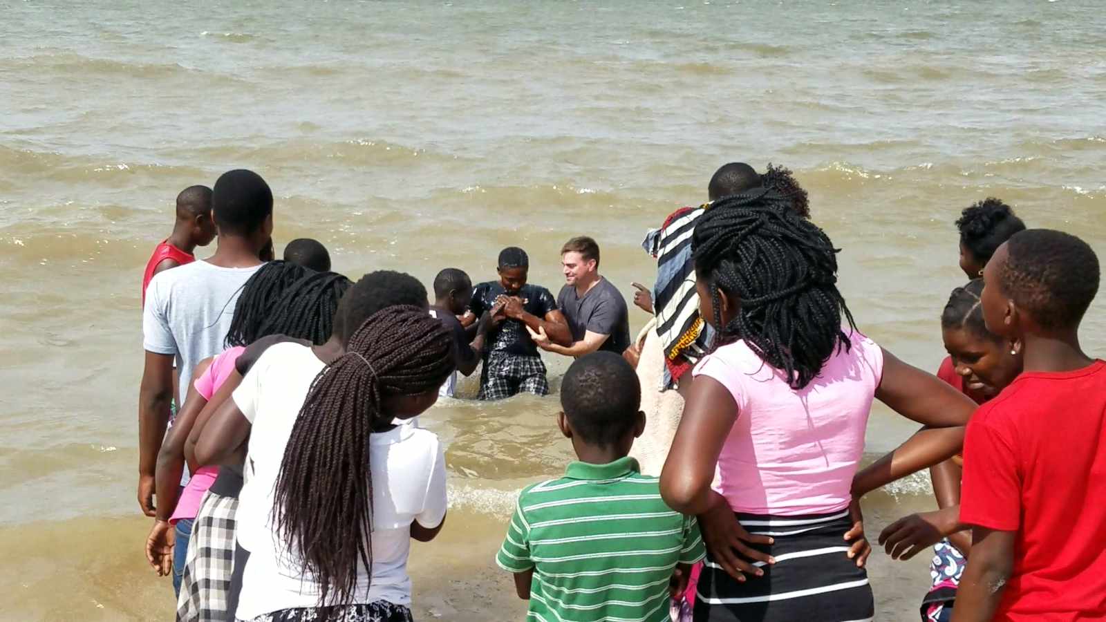 Jason and Abel baptizing a new believer in the ocean along the shore in Beira, Mozambique.