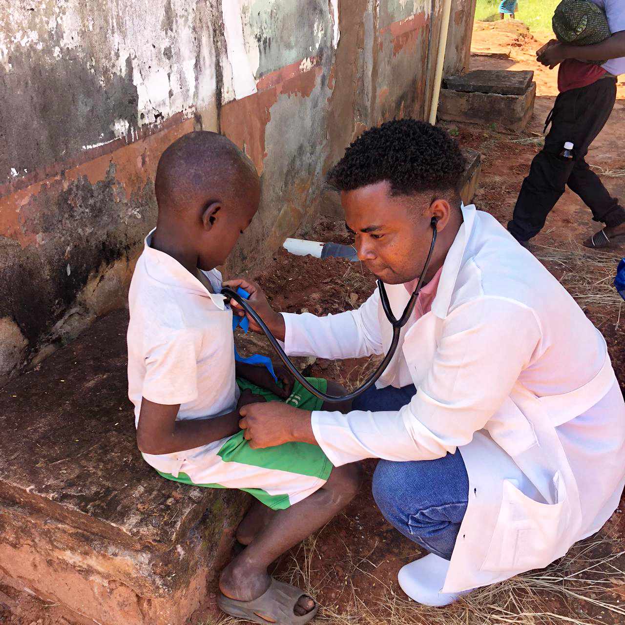 A health worker checking an elderly woman's blood pressure during a home visit in Mozambique