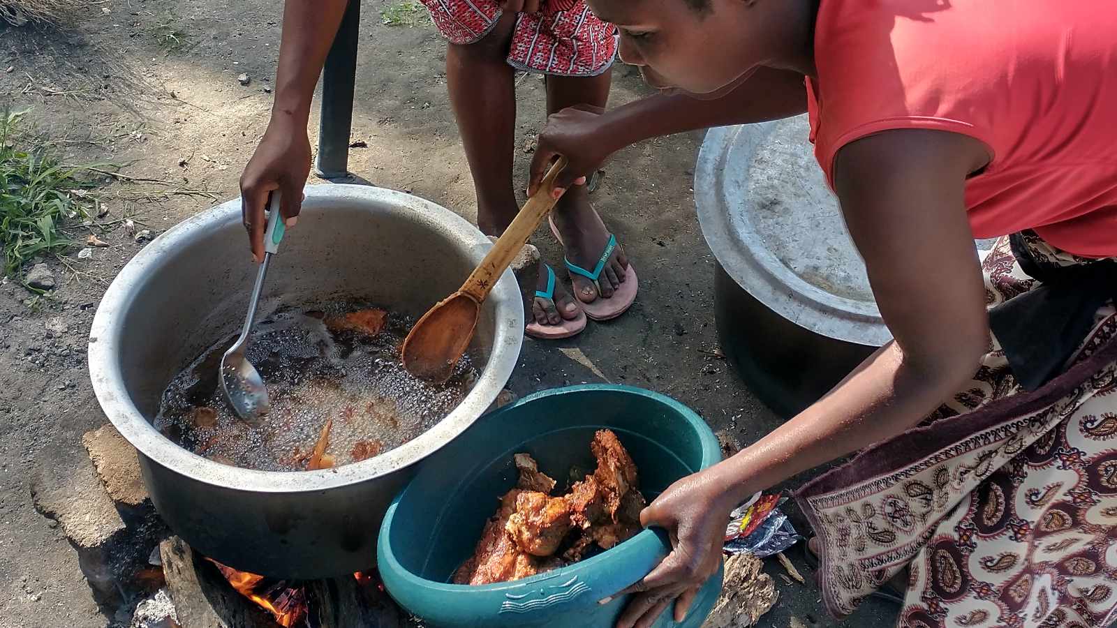 Women cooking fish over an open fire in a rural Mozambican community