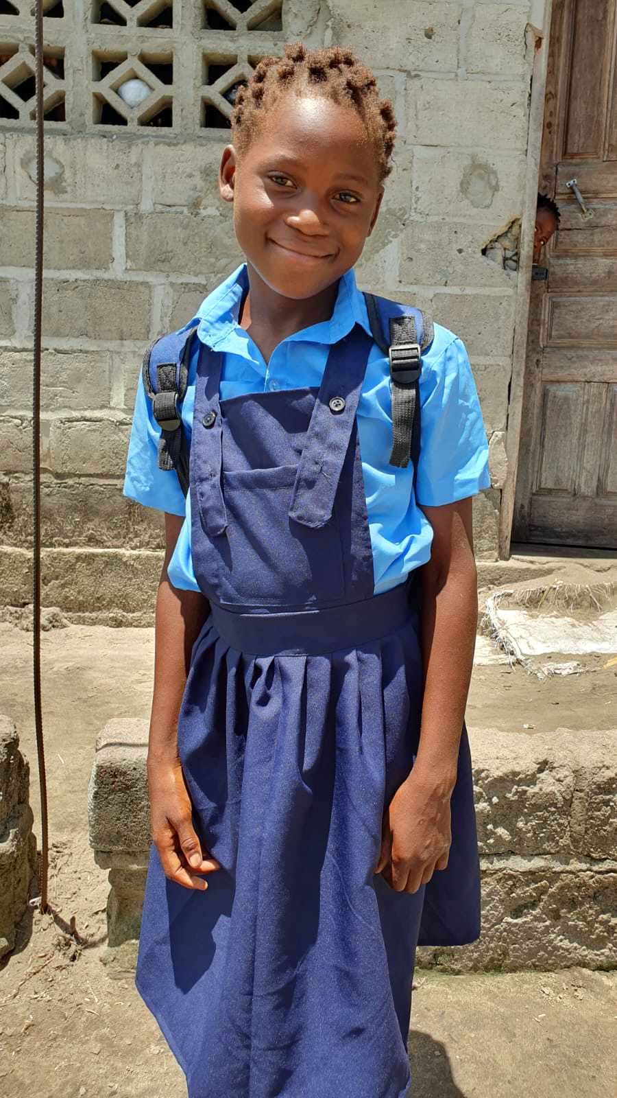 One of our girls - smiling as she heads back to school with her new uniform and backpack.